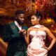 Akin Faminu holding hands with Kiky Festus, featuring his floral brooch and her embellished blush pink gown.