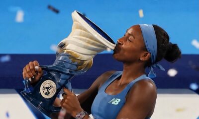 Coco Gauff kissing the Cincinnati Open trophy on stage after winning her second tournament title.