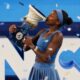 Coco Gauff kissing the Cincinnati Open trophy on stage after winning her second tournament title.