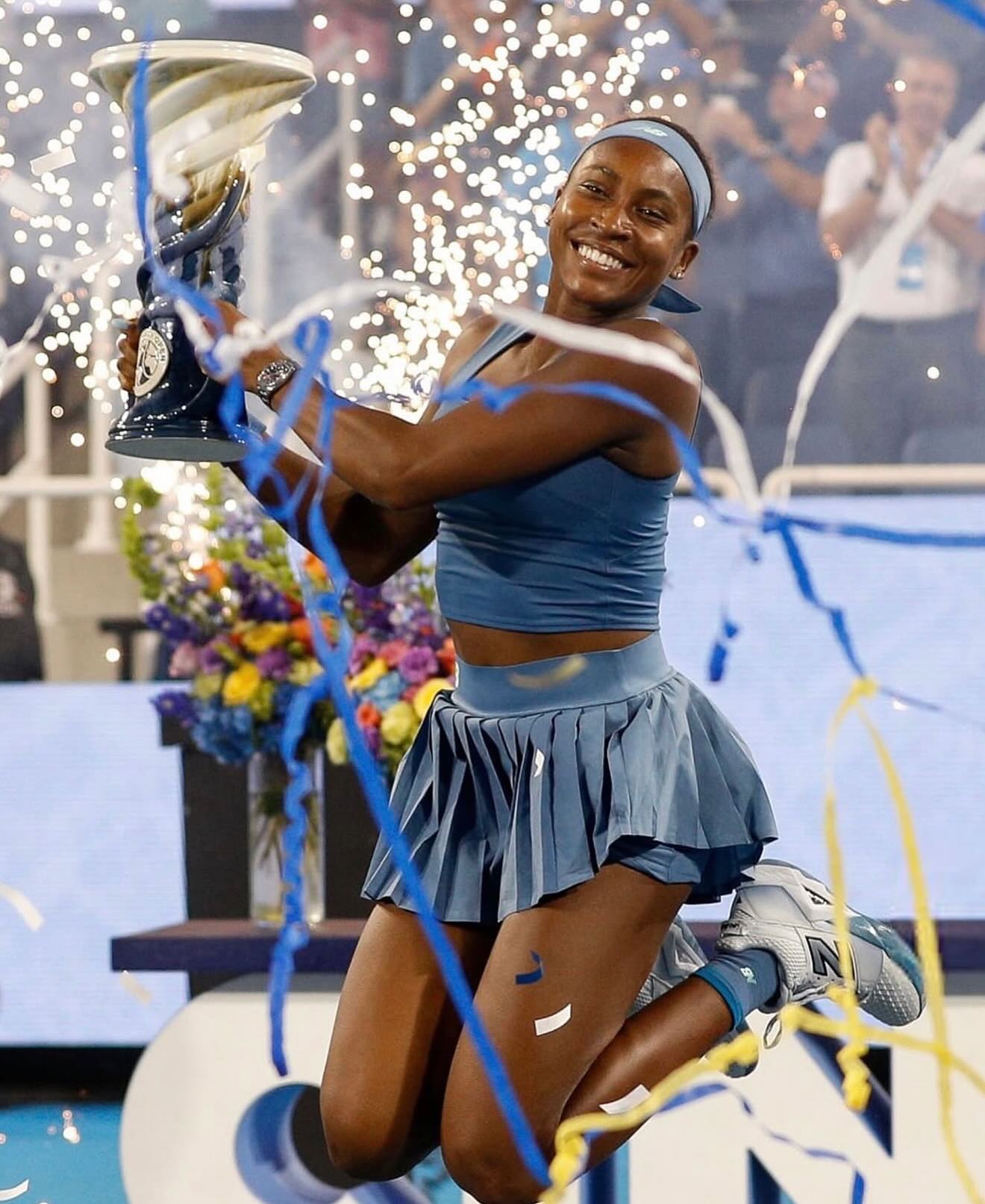 Coco Gauff leaping into the air with the Rookwood Cup amidst confetti following her Cincinnati Open win.