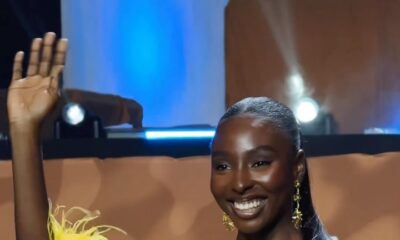 Tamunosoye Karibi George smiling and waving while wearing a yellow beaded mini dress and feather boa following her Top Model Africa win.