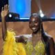 Tamunosoye Karibi George smiling and waving while wearing a yellow beaded mini dress and feather boa following her Top Model Africa win.