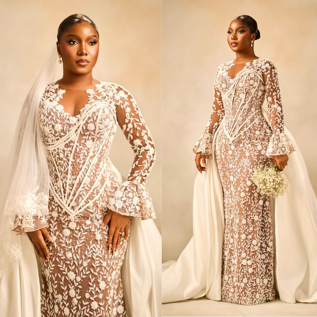 Simi Sanya wearing a long-sleeved sheer lace corset gown with bell cuffs, an overskirt train, and a sheer veil at the A Mama Deola Wedding Story premiere.