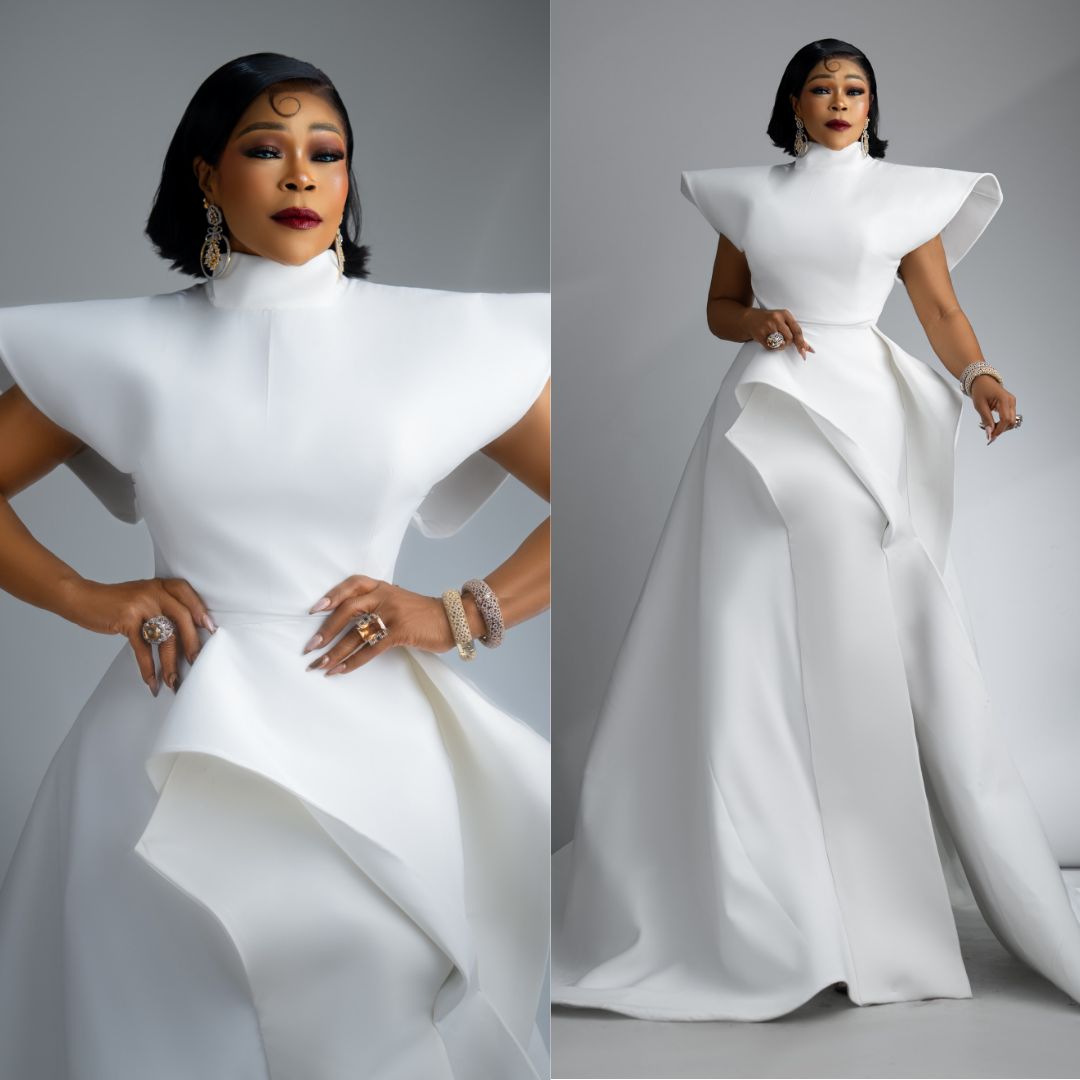 Shaffy Bello wearing an architectural high-neck white gown with structured shoulders and a folded skirt drape.
