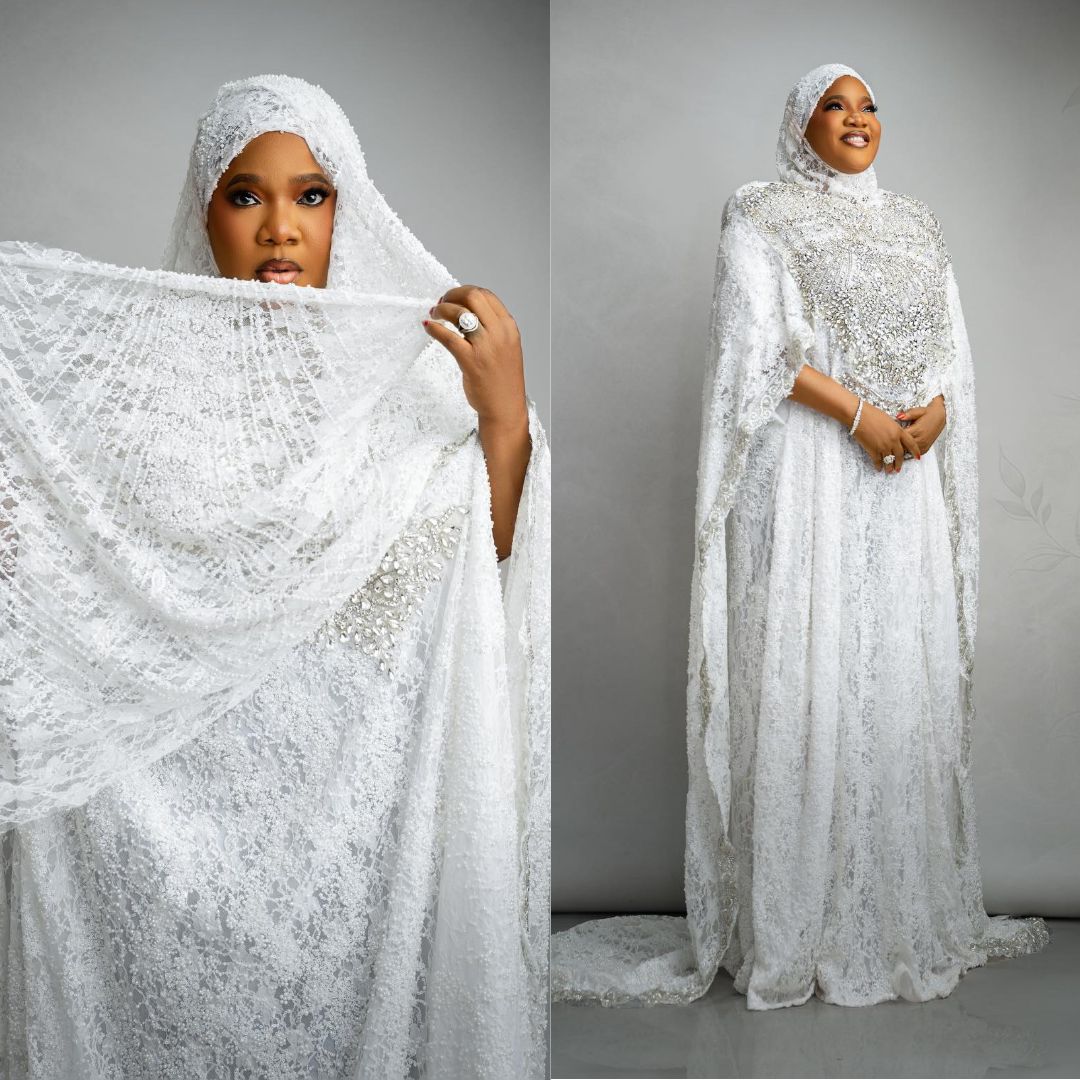 Toyin Abraham wearing an all-white lace kaftan gown with a matching head wrap veil and embellishments.