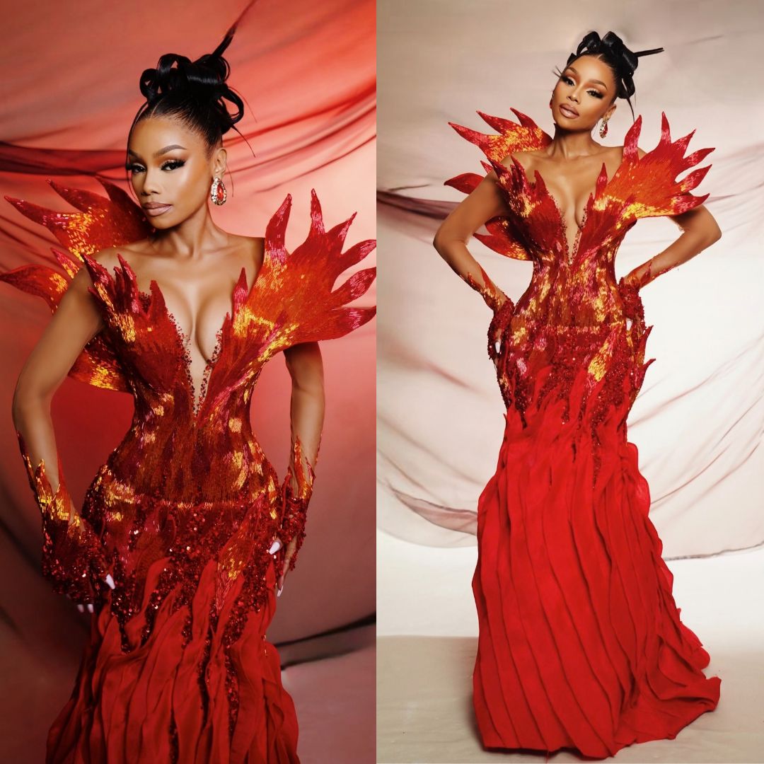 Bonang Matheba wearing a red and gold Emagine By Bukola gown with wing shoulder extensions for Miss Cosmo 2025