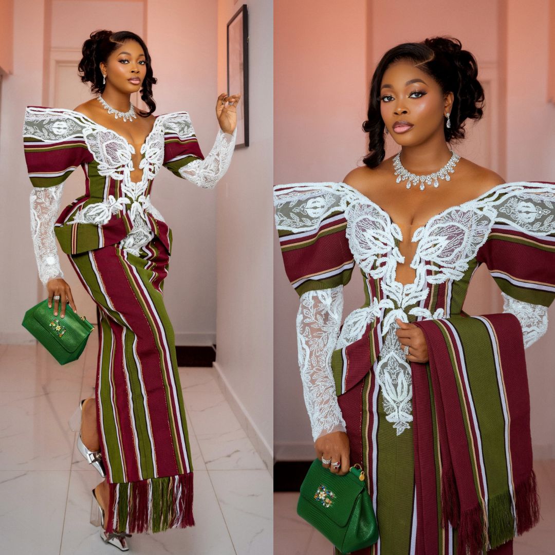KieKie wearing a maroon and green striped traditional fabric gown with white lace details at the Starlomo premiere.