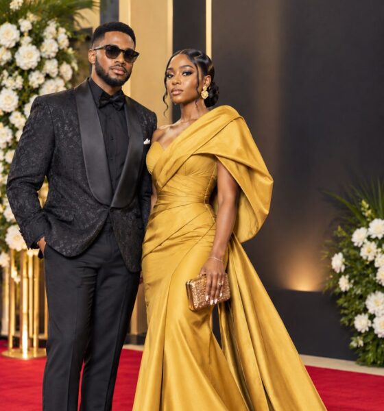 Couple on the red carpet wearing a mustard gold one-shoulder couture gown and a textured black tux for the BN 20 Gala High Fashion Icon dress code.