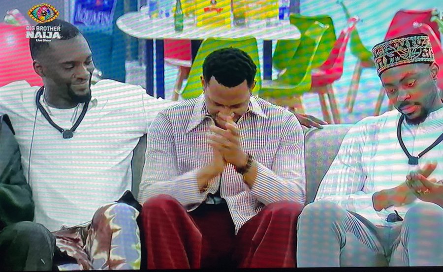 Housemate Barry reacting on the couch as fellow contestants applaud his Most Influential Player title win on Big Brother Naija Season 11.