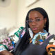 Former BellaNaija columnist Mrs Kush wearing pink glasses and a patterned top.