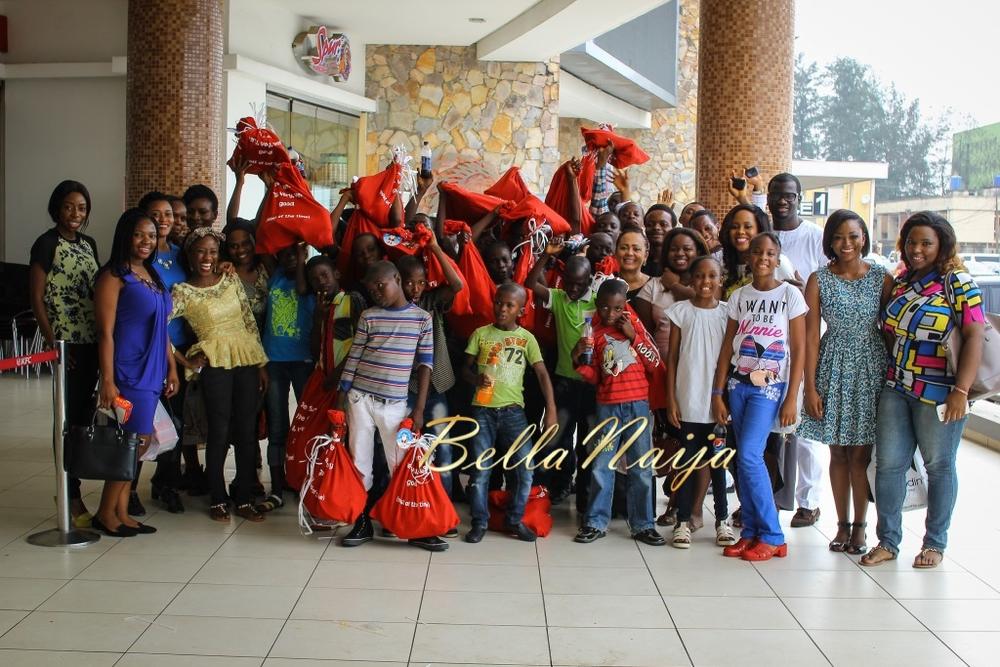 Beneficiaries holding festive gift bags alongside BellaNaija team at 2014 Christmas outreach with Child Life-Line.