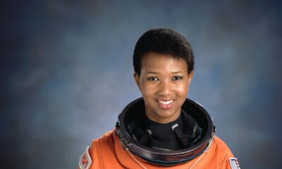 Dr Mae Jemison wearing an orange NASA Launch and Entry suit while holding her helmet.