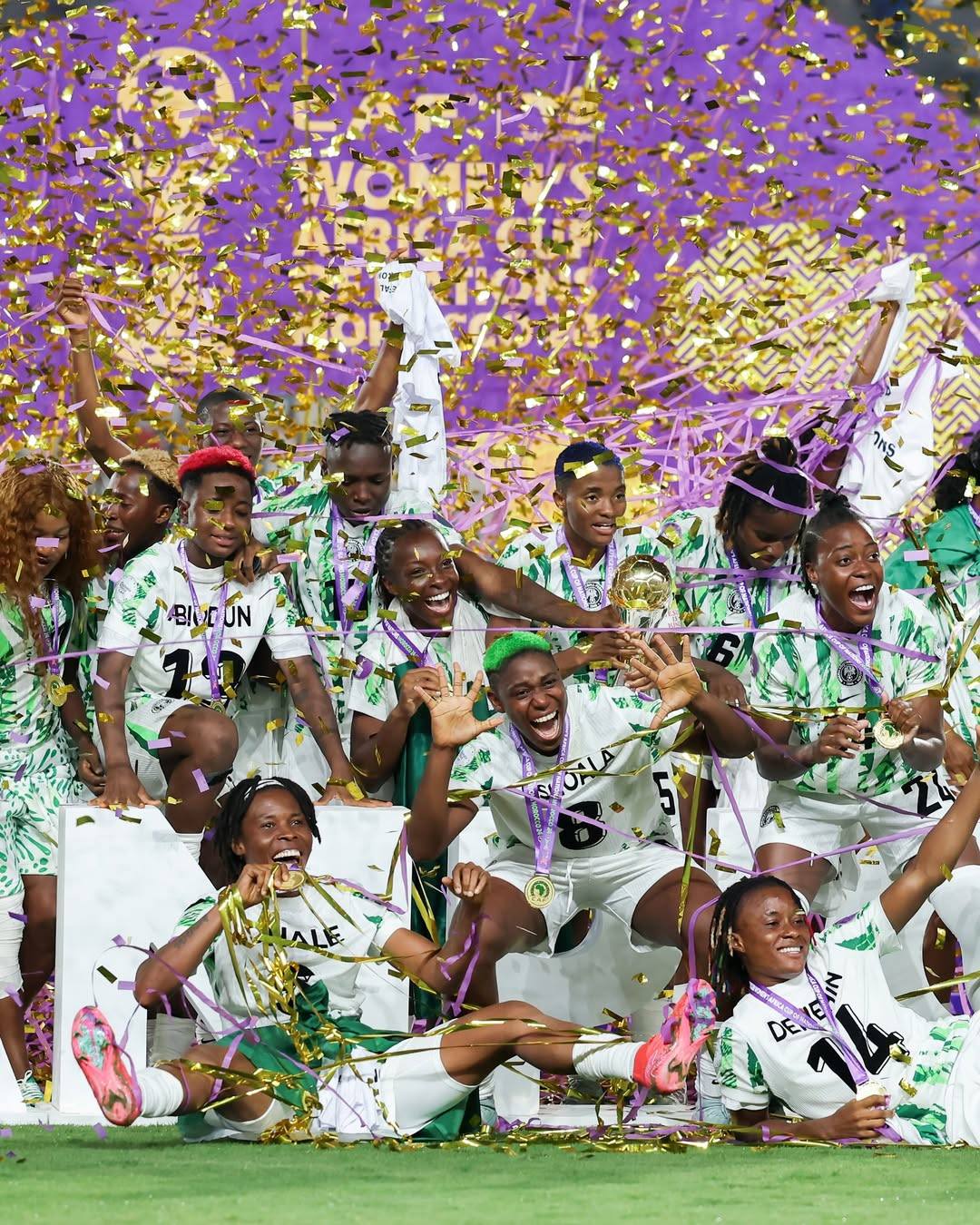 Osinachi Ohale and Super Falcons teammates celebrating a WAFCON title win under gold confetti during her 16-year Nigeria career