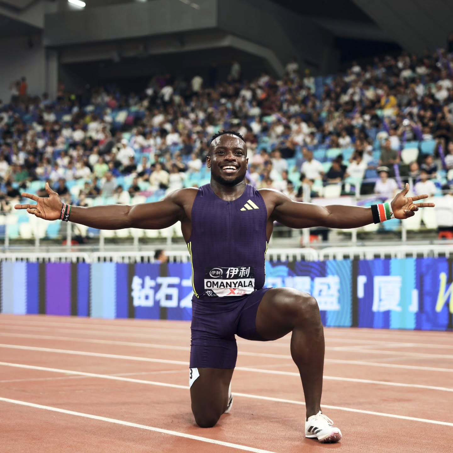 African 100m record holder Ferdinand Omanyala kneeling on the track in celebration after winning the Xiamen Wanda Diamond League 100m