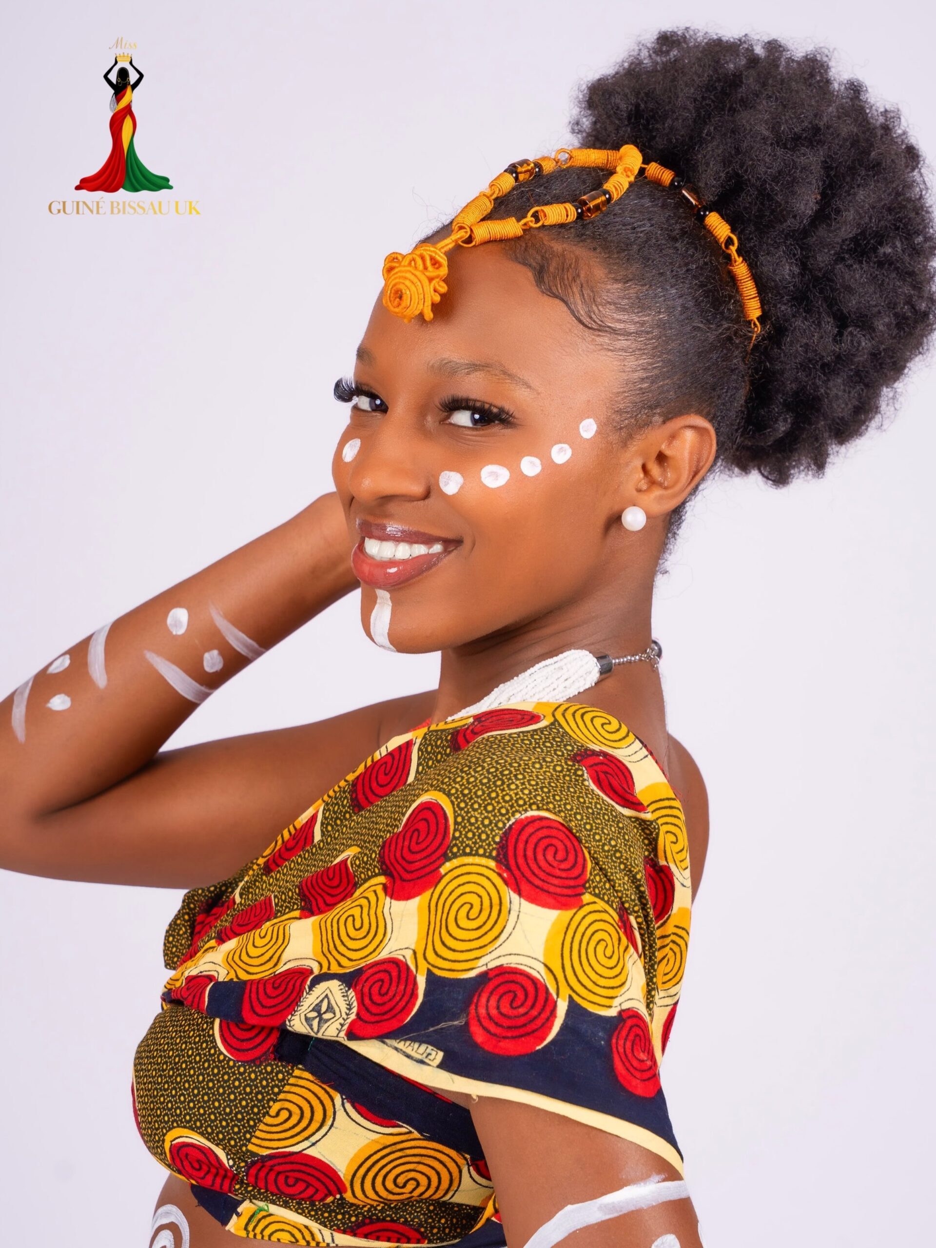 Melissa Djalo smiling while wearing a yellow beaded headpiece and patterned outfit for Miss Guiné-Bissau UK 2026