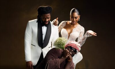 Laura Ajayi in a lace wedding gown and David Uruka in a white tuxedo standing behind Folagade Banks as Mama Deola