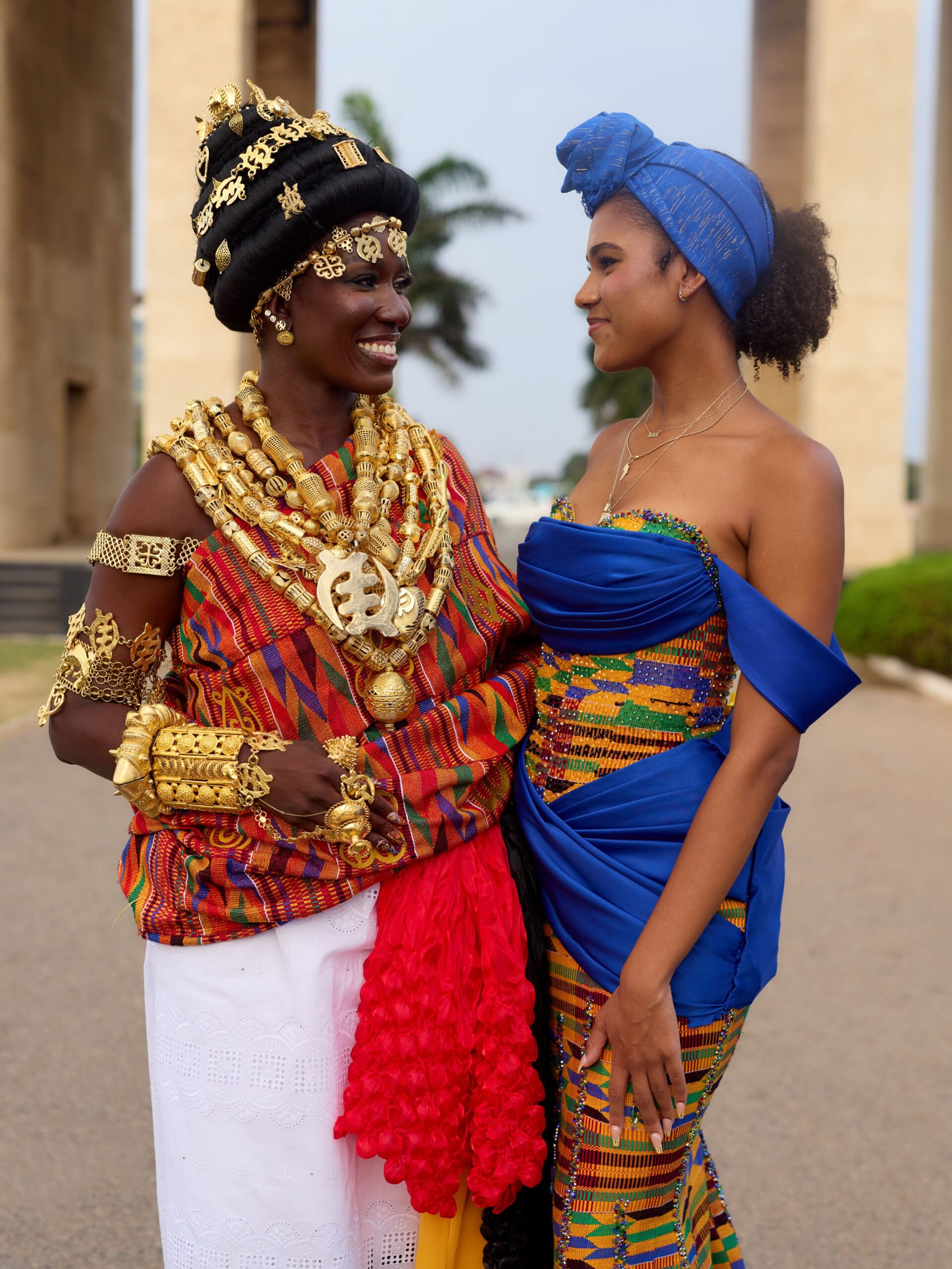 Bozoma Saint John in full Akan bridal regalia looking at her daughter Lael Saint John, who wears a vibrant blue Kente gown.