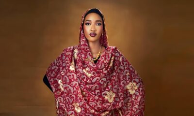 Bluethopia wearing maroon and gold traditional draped fabric with a matching head veil