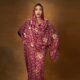 Bluethopia wearing maroon and gold traditional draped fabric with a matching head veil