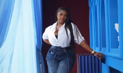 Dorathy Bachor wearing a white button-down shirt with high-waisted dark-wash wide-leg jeans and gold heels