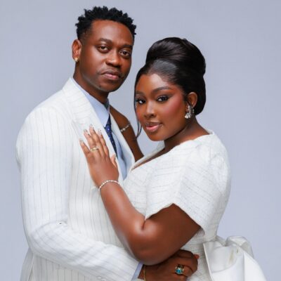 Mo Bimpe showcasing a high beehive updo and glam makeup next to Lateef Adedimeji