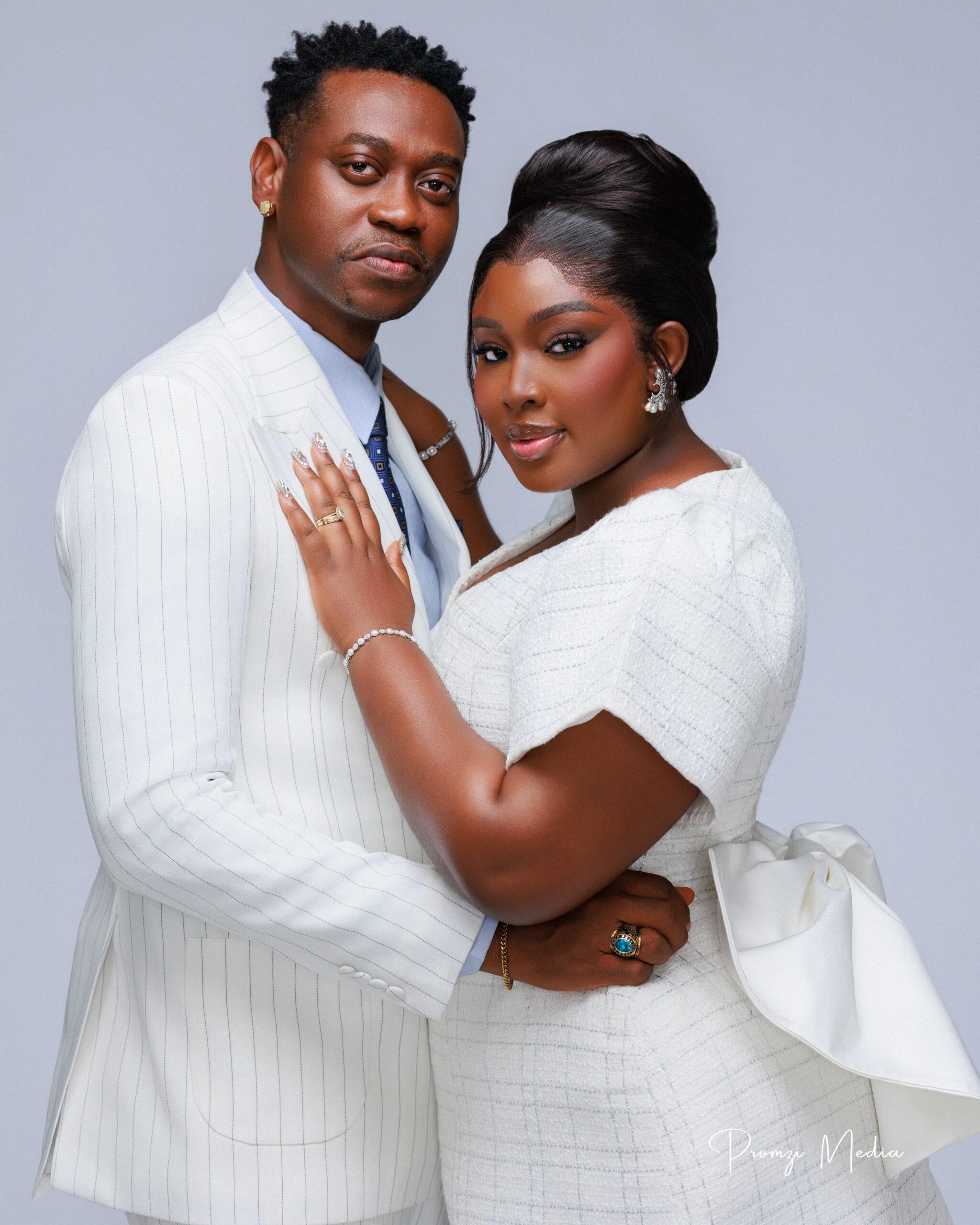 Mo Bimpe showcasing a high beehive updo and glam makeup next to Lateef Adedimeji