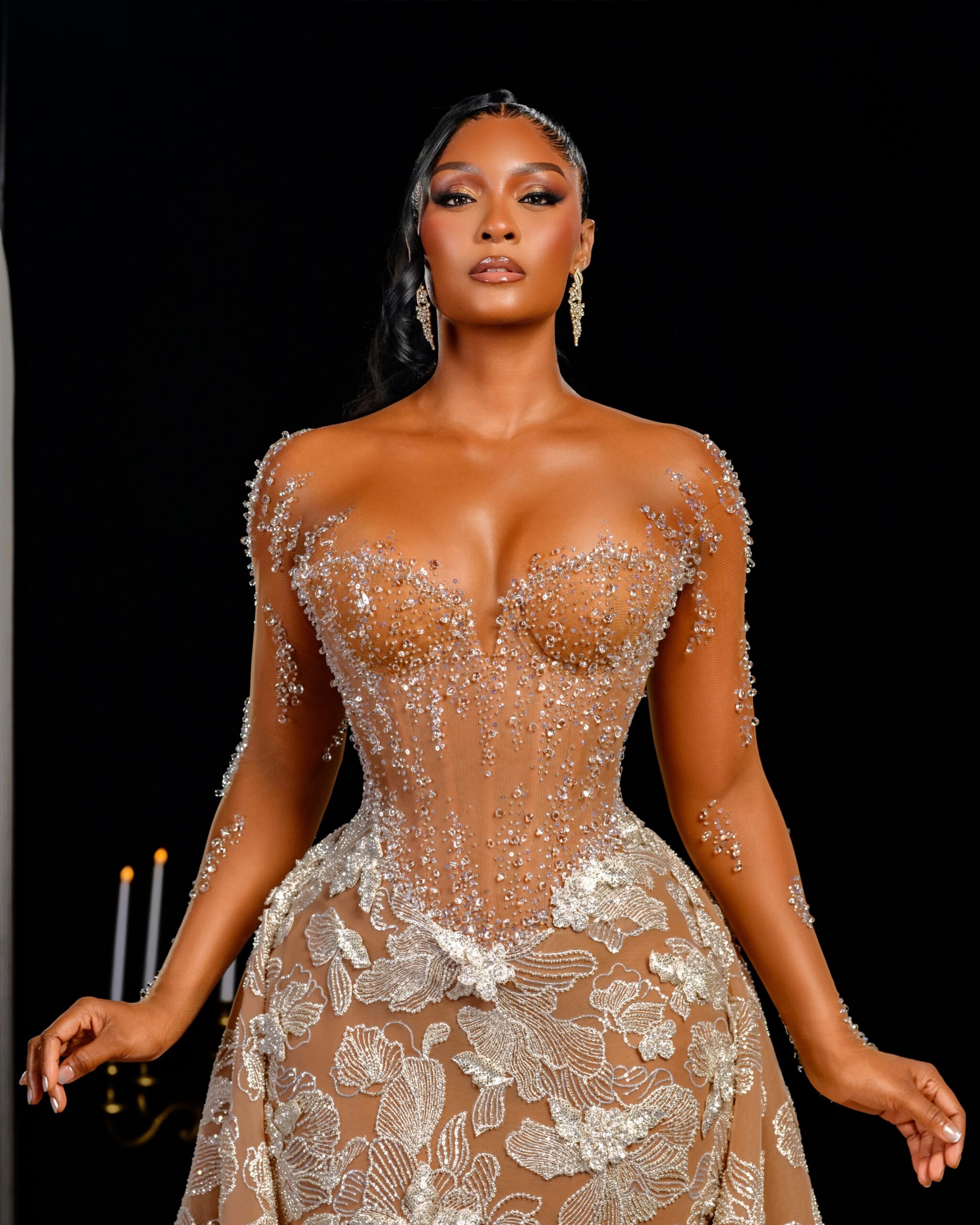 Osas Ighodaro with bronze glam makeup, high ponytail, and crystal drop earrings wearing Veekee James