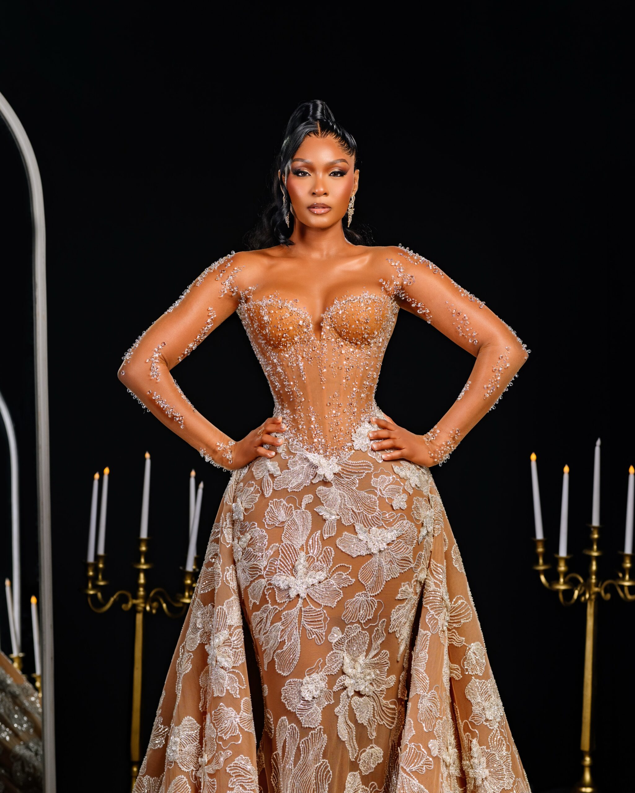 Osas Ighodaro posing in a floor-length sheer illusion lace corset dress by Veekee James