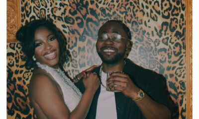 Hilda Baci wearing a white halter mini dress with beaded fringe beside partner Damilola Akinwunmi