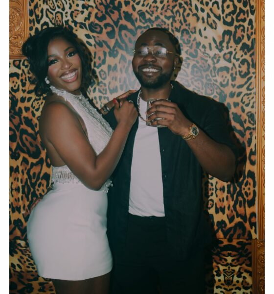 Hilda Baci wearing a white halter mini dress with beaded fringe beside partner Damilola Akinwunmi
