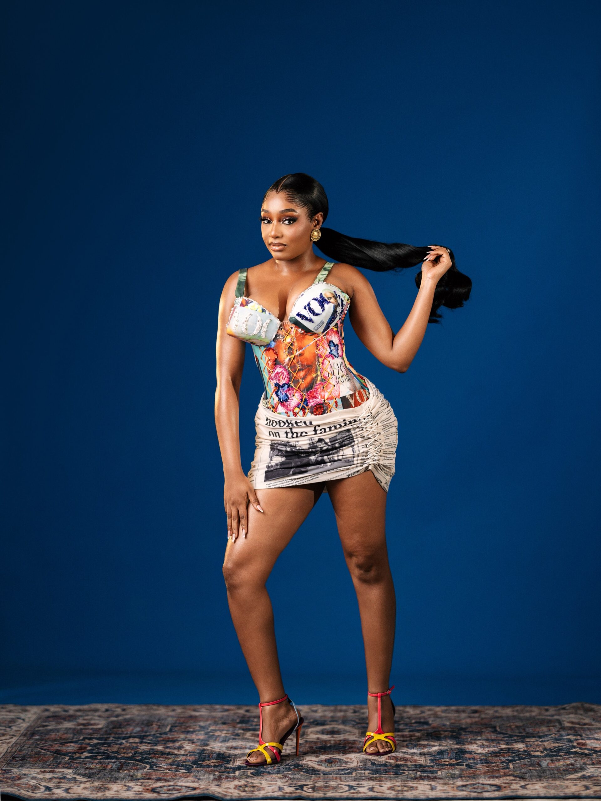 Kiky Festus in a custom Emagine By Bukola corset mini dress created from Vogue magazine covers and newspaper headline prints.