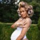 Ciara holding up five fingers in front of her baby bump to signal her fifth pregnancy.