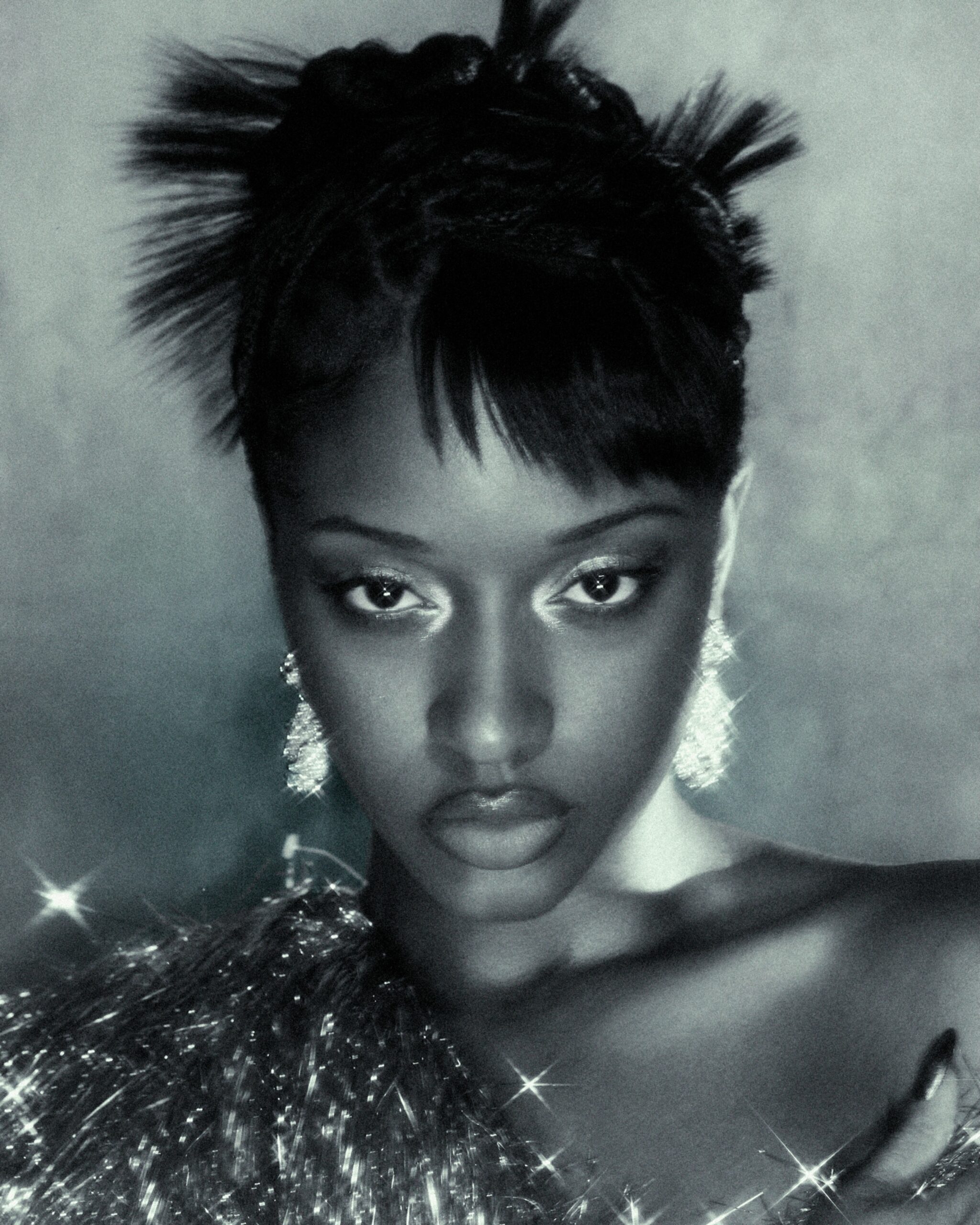 Ayra Starr wearing a textured spiky bun updo with wispy bangs and shimmering drop earrings, photographed by Fernando Tomaz for 66 GREENE Magazine.