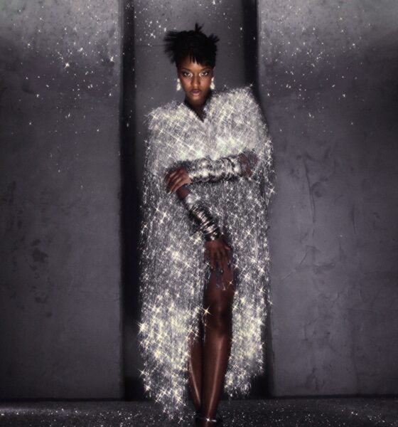 Ayra Starr in a shimmering silver tinsel cape dress with drop earrings, photographed by Fernando Tomaz for 66 GREENE Magazine.