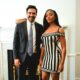 Ayra Starr in a black-and-cream striped dress standing beside Zohran Mamdani in a suit and slate-blue tie in New York.