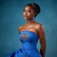 Dede Ashiogwu wearing a strapless royal blue dress with a heart-shaped beaded keyhole cutout and crystal teardrop earrings for the HookedOnTheFaminus white wedding.
