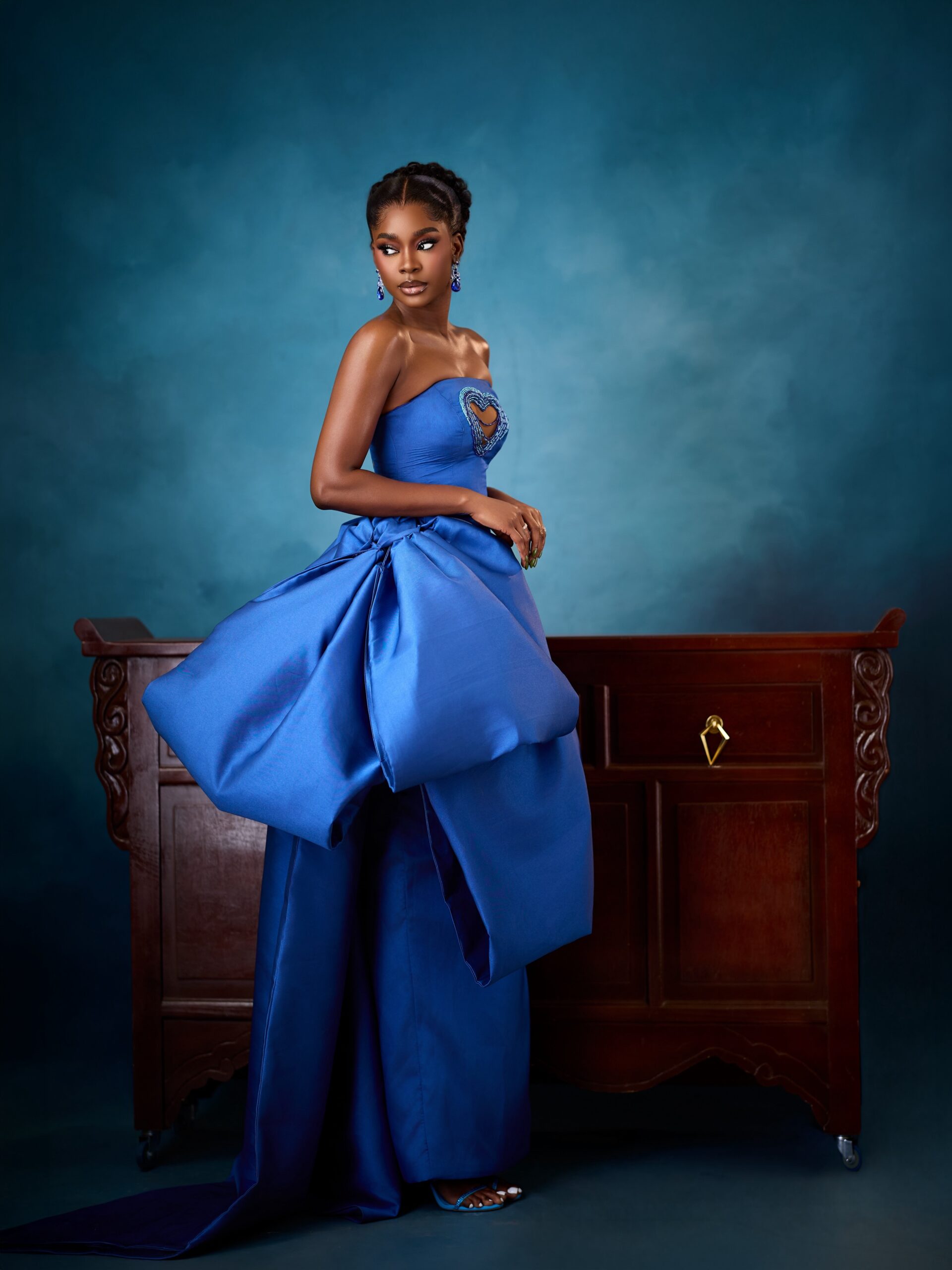 Dede Ashiogwu looking back showing the structured hip drape and train of her royal blue strapless dress.