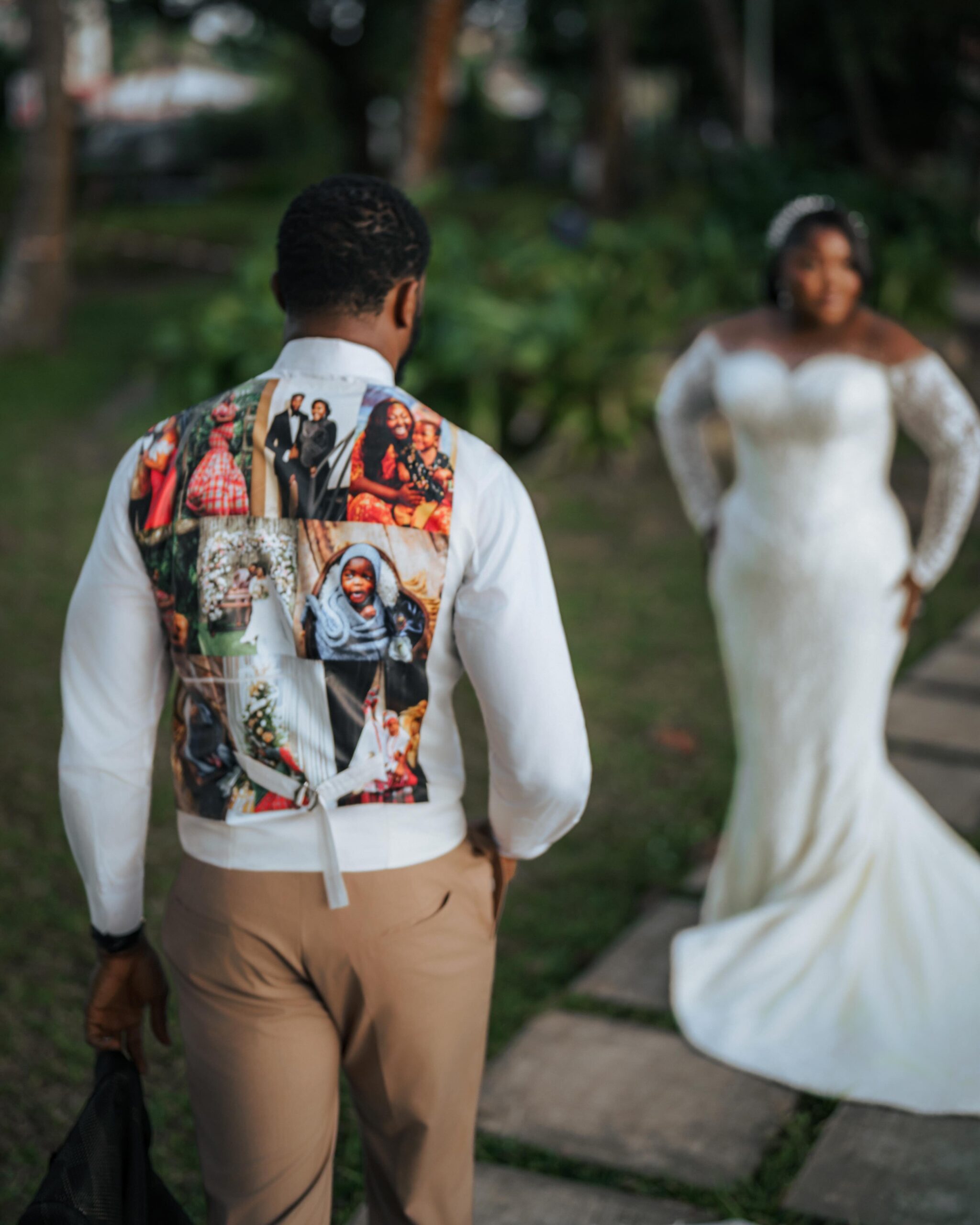 Back view of Stan Nze wearing P.Aries white vest with printed family photo collage as Blessing Obasi Nzediegwu stands in background.