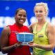 Katerina Siniakova and Taylor Townsend holding the US Open Women's Doubles trophy together.
