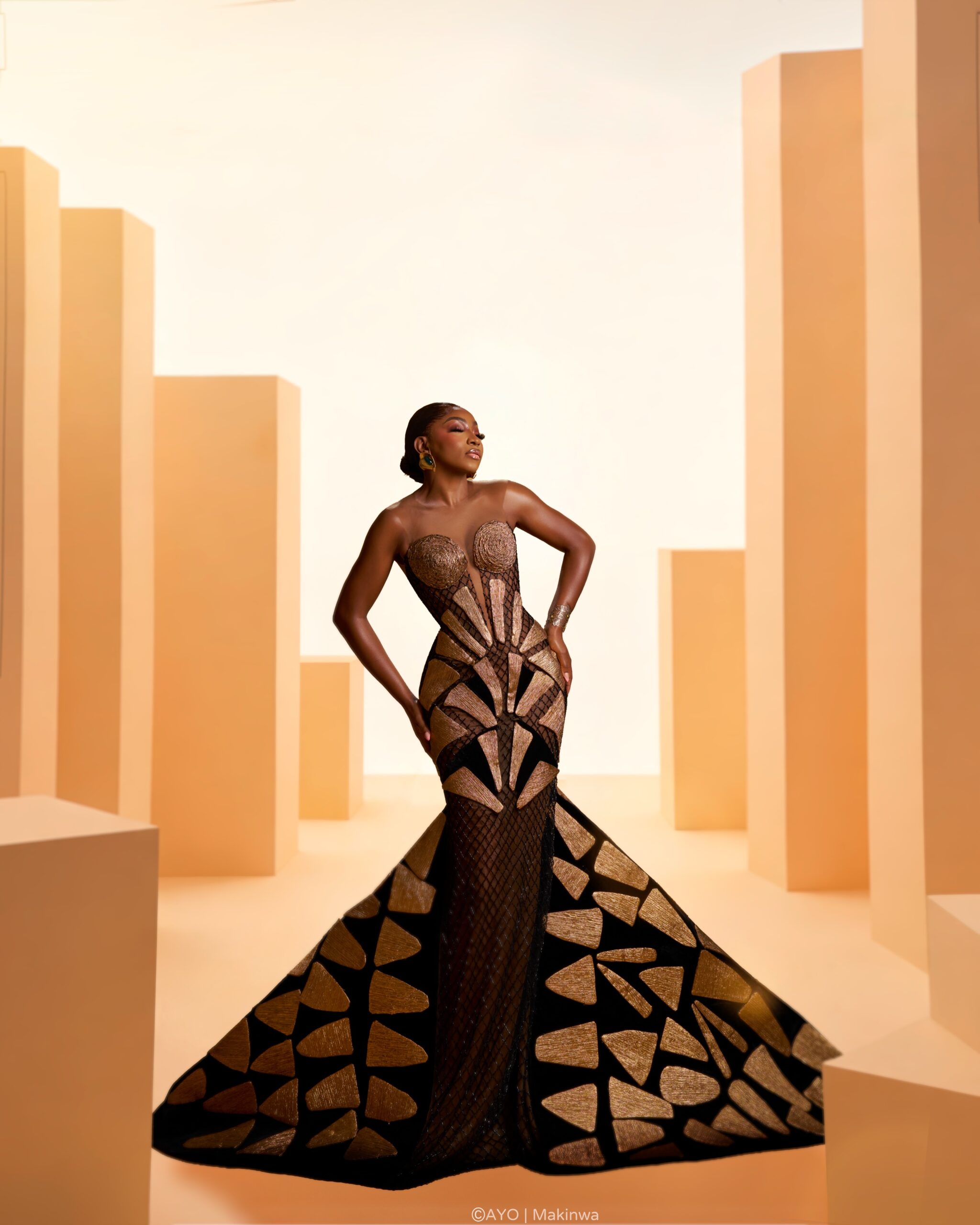 Omowunmi Dada in strapless Somobysomo gown featuring spiral bust embroidery and flared trumpet skirt.