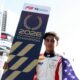 Ugo Ugochukwu holding the official 2026 FIA Formula 3 Champion board draped in the American flag.