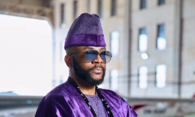 Ebuka Obi-Uchendu wearing layered black stone neck beads and a purple velvet agbada by D29 Africa.