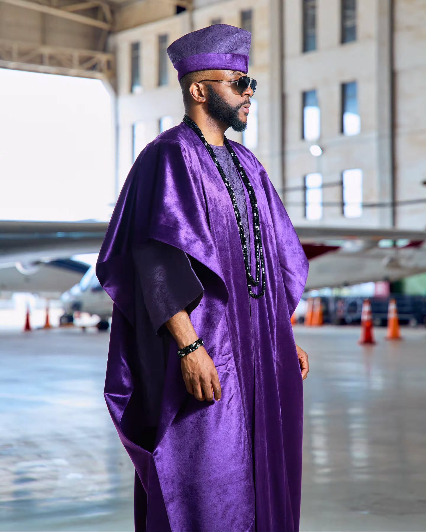 Ebuka Obi-Uchendu in profile wearing a purple velvet agbada and jacquard cap by D29 Africa.