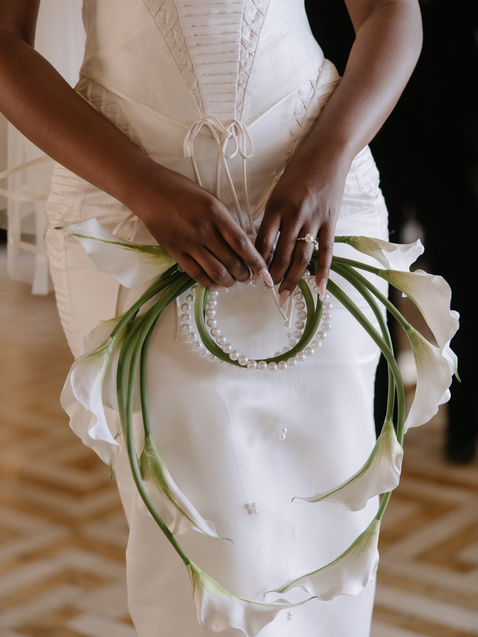 Circular pearl carry-handle bridal bouquet wrapped in calla lily stems for Ella and LAX white wedding in Malta.