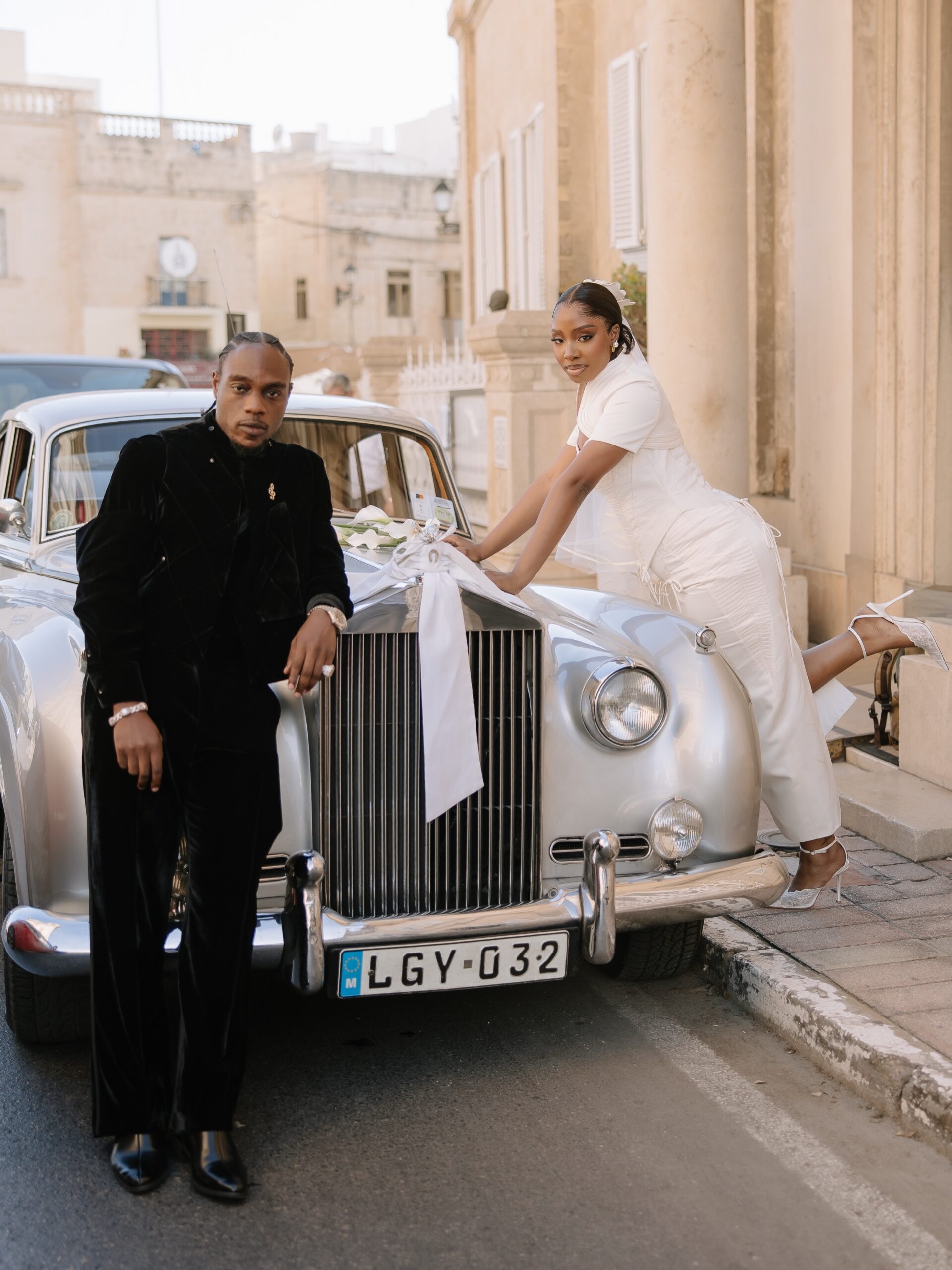LAX leaning on a vintage silver Rolls Royce while Ella poses on the hood in her wedding dress in Malta.