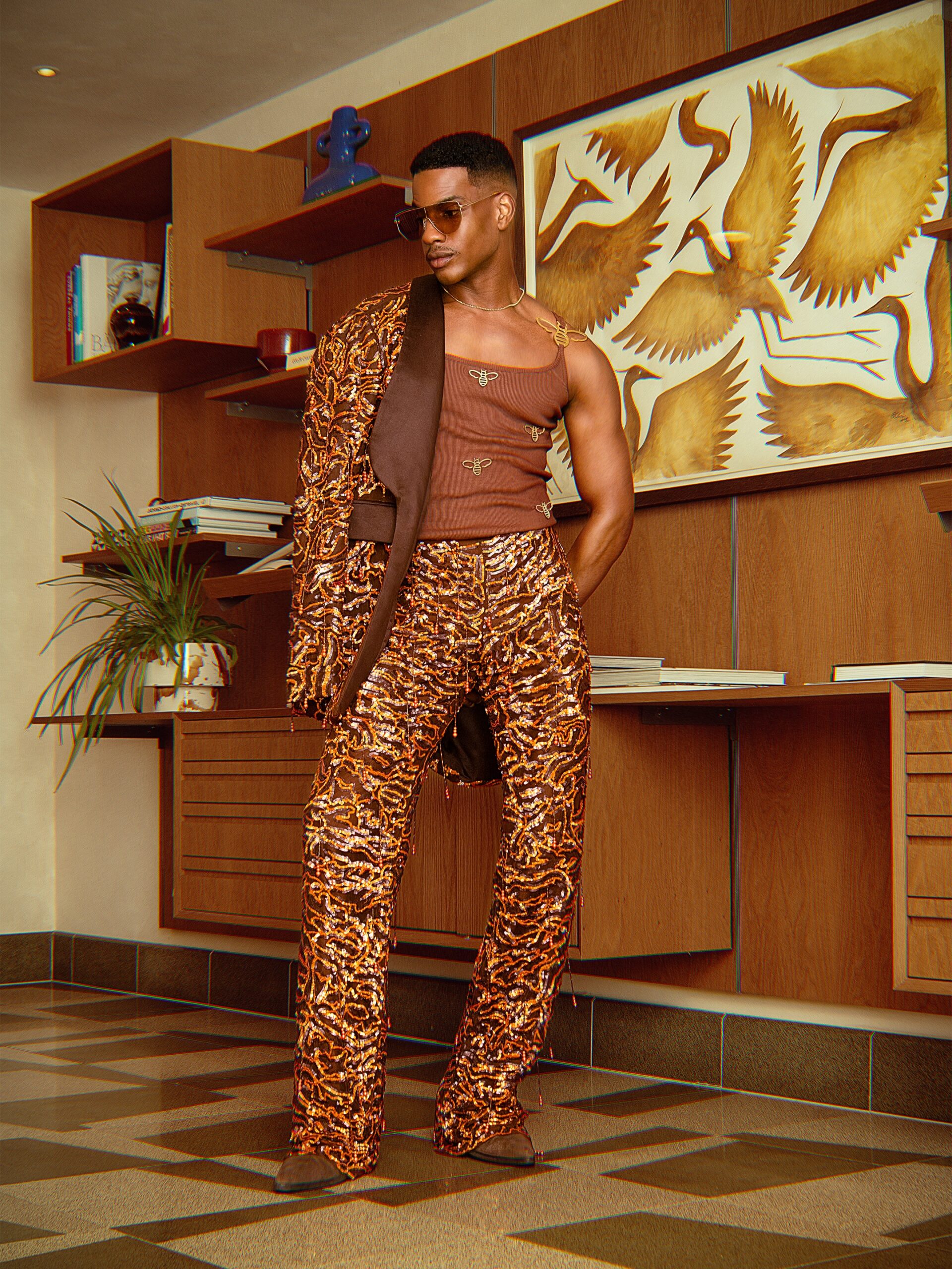 Denola Grey wearing a complete brown sequined mesh suit with gold bee top and retro aviator sunglasses for Onalaja SS27 at London Fashion Week