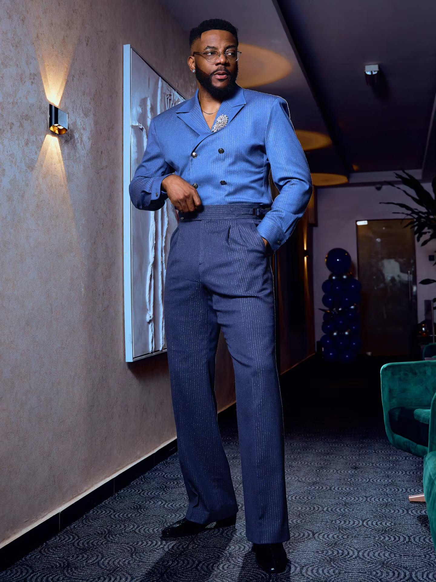 Ebuka Obi-Uchendu wearing a periwinkle double-breasted crossover shirt-jacket with navy pinstripe Gurkha trousers by Atafo.