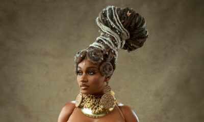 J’Dess posing in a crystal-embellished corset with basque peplum waist and a tiered raffia fringe skirt.
