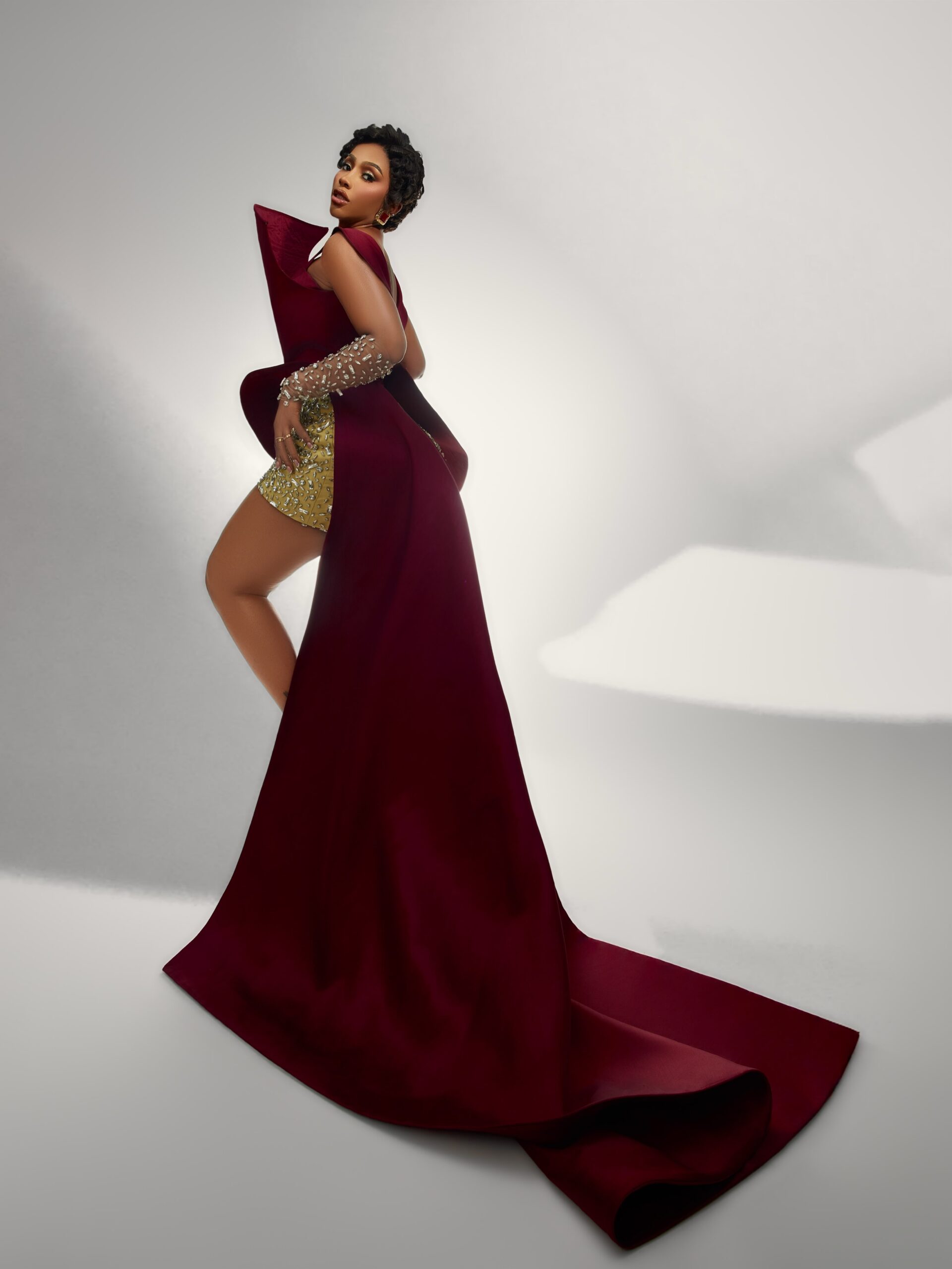 Mercy Eke displaying the sweeping floor length train of her maroon birthday top