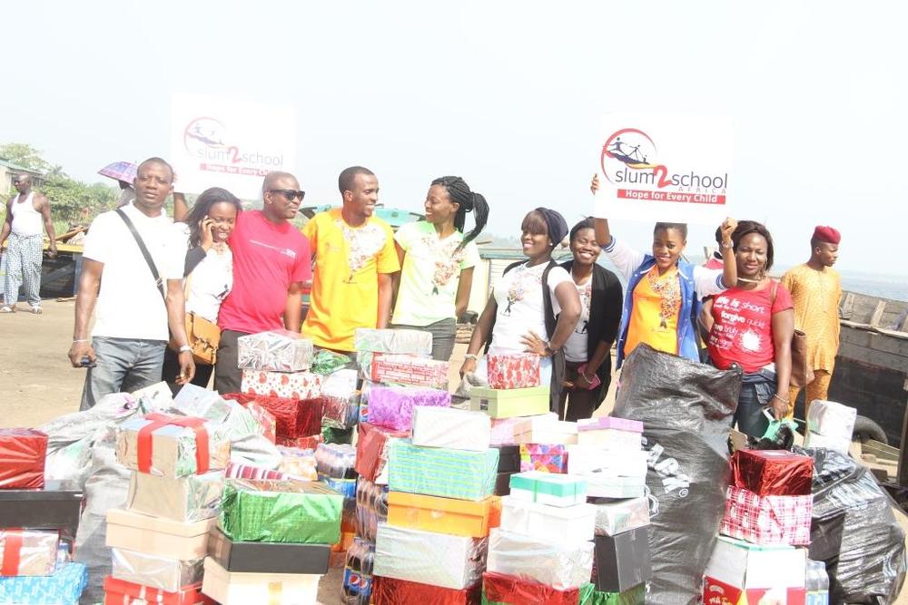 Slum2School Africa volunteers and BellaNaija team with stacks of Christmas gift boxes at Epe jetty for island outreach.